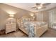 Relaxing main bedroom with a queen bed, nightstands with lamps, ceiling fan, and tile floor at 600 Manatee Ave # 143, Holmes Beach, FL 34217