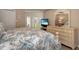 Comfortable main bedroom featuring a queen bed, dresser with mirror, and sliding door to outdoor space at 600 Manatee Ave # 143, Holmes Beach, FL 34217