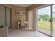Bright sunroom/patio with tile floor, desk, and sliding glass door to outdoor green space at 600 Manatee Ave # 143, Holmes Beach, FL 34217