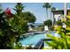 Outdoor pool area showcasing lounge chairs and a glimpse of the waterfront beyond lush tropical foliage at 600 Manatee Ave # 143, Holmes Beach, FL 34217