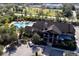 Aerial view of the community clubhouse featuring a pool, parking, and surrounding green spaces at 6017 Maidenstone Way, Palmetto, FL 34221