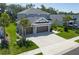 Aerial view of a beautiful home featuring a three-car garage, lush yard, and lovely landscaping at 6017 Maidenstone Way, Palmetto, FL 34221