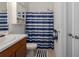 Small bathroom with a white sink vanity and a white and blue shower curtain at 6017 Maidenstone Way, Palmetto, FL 34221