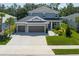 Beautiful two-story home showcasing a three-car garage and a well-manicured lawn at 6017 Maidenstone Way, Palmetto, FL 34221