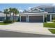 Stunning home with a three-car garage, mature palm trees, and a pristine driveway at 6017 Maidenstone Way, Palmetto, FL 34221