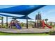 Outdoor playground features a pirate ship themed playset and a blue sunshade for sun protection at 6017 Maidenstone Way, Palmetto, FL 34221