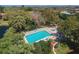 Aerial view of a community pool with hot tub surrounded by trees and landscaping at 6412 Sun Eagle Ln, Bradenton, FL 34210