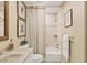 Bathroom featuring a framed mirror, with a tub-shower combination and neutral tile surround at 6412 Sun Eagle Ln, Bradenton, FL 34210