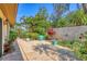 An outdoor patio surrounded by tropical landscaping with lush greenery, trees, and colorful plants at 6412 Sun Eagle Ln, Bradenton, FL 34210
