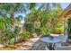 A beautifully landscaped patio with lush greenery, colorful plants, and comfortable seating creates a tranquil outdoor space at 6412 Sun Eagle Ln, Bradenton, FL 34210
