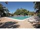 The rectangular pool with lounge chairs is surrounded by beautiful tropical landscaping and trees at 6412 Sun Eagle Ln, Bradenton, FL 34210