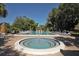 Community pool and hot tub surrounded by lounge chairs and lush landscaping at 6412 Sun Eagle Ln, Bradenton, FL 34210