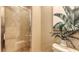 This powder room includes a glass shower, ceramic tile, and a decorative plant on top of the toilet at 6465 Watercrest Way # 404, Lakewood Ranch, FL 34202