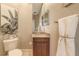 This half bath features a granite countertop vanity, decorative mirror and towel, and a decorative plant at 6465 Watercrest Way # 404, Lakewood Ranch, FL 34202