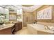 Luxurious bathroom featuring a soaking tub, walk-in shower, and granite countertops at 6465 Watercrest Way # 404, Lakewood Ranch, FL 34202