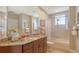 Well-lit bathroom features granite countertops, a large mirror, and a shower-tub combination at 6465 Watercrest Way # 404, Lakewood Ranch, FL 34202