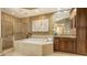 Elegant bathroom featuring a tub, walk-in shower, custom cabinets, and granite countertops at 6465 Watercrest Way # 404, Lakewood Ranch, FL 34202