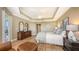 Spacious bedroom featuring tray ceilings, hardwood floors, and sliding doors to balcony at 6465 Watercrest Way # 404, Lakewood Ranch, FL 34202