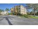Beautiful building with landscaped grounds, palm trees, and plenty of parking on a sunny day at 6465 Watercrest Way # 404, Lakewood Ranch, FL 34202
