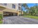 This ground level garage features an opening into the complex's garage and a grassy area with palm trees nearby at 6465 Watercrest Way # 404, Lakewood Ranch, FL 34202