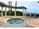 Relaxing hot tub area with pergola and brick pavers offering a serene outdoor space at 6465 Watercrest Way # 404, Lakewood Ranch, FL 34202