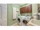 This laundry room features a washing machine, dryer, sink, granite countertop and matching cabinets at 6465 Watercrest Way # 404, Lakewood Ranch, FL 34202