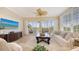 Bright living room with sliding glass doors to the lanai, ceiling fan, and comfortable furnishings at 6465 Watercrest Way # 404, Lakewood Ranch, FL 34202