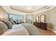 Comfortable main bedroom featuring hardwood floors, tray ceilings, and balcony access at 6465 Watercrest Way # 404, Lakewood Ranch, FL 34202