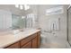 Well-lit bathroom featuring a shower with glass doors, and white and brown cabinets for storage at 7424 Arrowhead Run, Lakewood Ranch, FL 34202