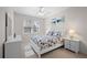 Bright bedroom features a large window, neutral carpet, white furniture, and ceiling fan at 7424 Arrowhead Run, Lakewood Ranch, FL 34202