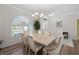 Dining room with a wooden table, six chairs, hardwood flooring, and a large window at 7424 Arrowhead Run, Lakewood Ranch, FL 34202