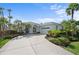 Charming single-story home featuring a well-manicured lawn, mature palm trees, and a two-car garage at 7424 Arrowhead Run, Lakewood Ranch, FL 34202