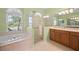 Main bathroom featuring a soaking tub beneath a window and a glass enclosed shower at 7424 Arrowhead Run, Lakewood Ranch, FL 34202