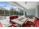 Covered patio with a large table and red chairs overlooking the pool, perfect for outdoor entertaining at 7424 Arrowhead Run, Lakewood Ranch, FL 34202