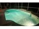 Screened-in pool with steps that is lit-up at night and ready for an evening swim at 7424 Arrowhead Run, Lakewood Ranch, FL 34202