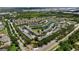 The aerial view captures the community layout around a pond, surrounded by trees and roads at 7593 Plantation Cir, Bradenton, FL 34201