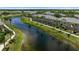 Picturesque aerial view shows the townhomes with manicured lawns next to a calming lake at 7593 Plantation Cir, Bradenton, FL 34201