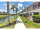 Picturesque backyard featuring a screened patio, lush landscaping, and tranquil water views at 7593 Plantation Cir, Bradenton, FL 34201