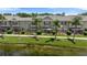 This backyard features screened in porches with palm trees and beautiful landscaping near the water at 7593 Plantation Cir, Bradenton, FL 34201