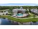 The clubhouse features an inviting pool, elegant architecture, and manicured grounds by a lake at 7593 Plantation Cir, Bradenton, FL 34201