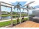 Relaxing screened lanai provides tranquil views of a pond surrounded by well-maintained community grounds and lush palm trees at 7593 Plantation Cir, Bradenton, FL 34201