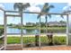 Enclosed lanai overlooking a tranquil pond with palm trees and lush landscaping, perfect for relaxation at 7593 Plantation Cir, Bradenton, FL 34201