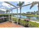 Inviting screened lanai with scenic views of a peaceful pond surrounded by palm trees and community landscaping at 7593 Plantation Cir, Bradenton, FL 34201