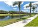 Scenic view of a community pond with lush landscaping and palm trees at 7593 Plantation Cir, Bradenton, FL 34201