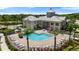 Aerial view of a pool, chairs, and a beautifuly built clubhouse surrounded by palm trees at 7593 Plantation Cir, Bradenton, FL 34201