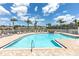 Community pool featuring a waterfall, lounge chairs, and nearby residential buildings at 7593 Plantation Cir, Bradenton, FL 34201