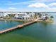 Stunning aerial view of a lakefront community with white homes, a bridge, and lush landscaping under a blue sky at 8209 72Nd E St, University Park, FL 34201
