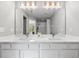 Modern bathroom featuring double sinks, a large mirror, and updated lighting at 8209 72Nd E St, University Park, FL 34201