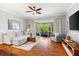Bright living room featuring hardwood floors, a ceiling fan, and sliding glass doors to the outside at 8209 72Nd E St, University Park, FL 34201