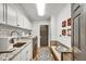 Charming laundry room features white cabinets, subway tile backsplash, granite counters, and stylish décor at 8950 Misty Creek Dr, Sarasota, FL 34241
